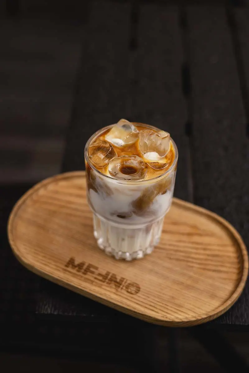 Освіжаюча кава з льодом та молоком у склянці на дерев'яній таці в Muffin Cafe ТЦ Грушевський.